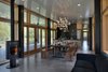 The architects specified fir wood to encase the windows and impart a warm ochre to the house’s otherwise industrial material palette. The picnic-style dining table was designed by CAST in collaboration with Seattle furniture maker Joe Burmeister. The chandelier is by Nemo Italianaluce. Photo of Modern Mountain Retreat in Washington modern home