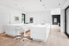 Modern home with Kitchen, White Cabinet, and Light Hardwood Floor. White was used extensively throughout the addition, a choice that the architects say enhances the spacious feel of the rooms and draws attention to the views. Photo of Airy Kitchen Additions