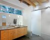 Matching Ladena sinks by Kohler, outfitted with Talis S faucets by Hansgrohe, stand inside polished Stormy Sky countertops by PentalQuartz. Photo 7 of Courtyard House on a River modern home