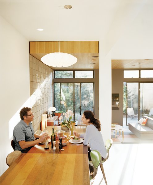 Krubiner (here, with girlfriend Kylie Gordon) furnished the house with finds from Craigslist and eBay, such as the 1970s Milo Baughman dining table and Norman Cherner chairs.