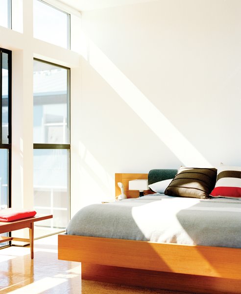 In the light-filled bedroom is a vintage teak coffee table and a Danish modern floating bed.
