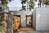 Architect Mary Ann Schicketanz transformed the old entryway into a private courtyard, replacing the door and window with a sleek glass slider. She removed the fiberglass panels and constructed a reclaimed wood barrier to separate the sitting area from the new front door on the opposite side. A high concrete wall also encloses it. “I love that you can be right on the street without having any sense the street is there,” Schicketanz says. Photo of Torres House modern home