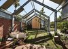 The outdoor area features an Apaiser tub. Opposite the house, on the other end of the garden, sits a music studio. "We are aiming to have the garden and house flow into each other,” says resident Michelle. Photo 4 of Cut Cut Paw Paw modern home