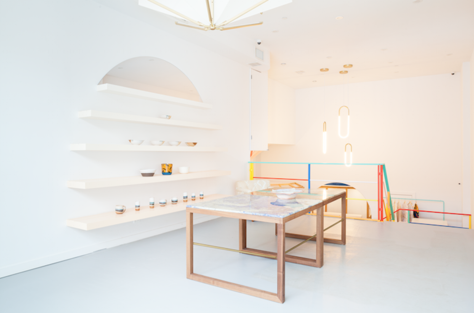 The marble topped tables in the entryway were designed with Archer Modern. The floating shelves display registry items made by local artisans.