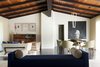 Modern home with Living Room, Sofa, and Chair. A vintage bar unit, a Tube Chandelier by Michael Anastassiades, and a David Harouni artwork are highlights in the open-plan living and dining space. The architects removed heavy paneling from the walls to lighten the space. Photo of Clean Update for a Midcentury House in Pennsylvania
