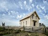 Though it changed locations when it moved to Shobac, the updated schoolhouse has the same orientation as it once did—the entrance sits on the east end of the house. The exteior features clapboard walls and a cedar shingled roof. Photo of Schoolhouse Salvaged as a Cozy Cabin modern home