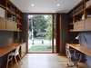 Modern home with Office, Study Room Type, Chair, Bookcase, Medium Hardwood Floor, Shelves, Desk, and Lamps. The study features floor-to-ceiling sliding glass doors that bring the outdoors in. Space-saving custom walnut desks are accented by a Pixo Optical LED Table Lamp, an AJ table lamp, and a 1958 Eames Management Chair. Photo of A Modern Toronto House Covered by a Contemporary Solar Screen