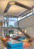 Modern home with Living Room, Ceiling Lighting, Sofa, and End Tables. Trejos positioned the containers about 60 centimeters above the ground floor, which gives the main gallery and workspace a bit of a sunken feel. The double-level main room offers a spacious interior, perfect for large events and easily altered so it can be utilized as a photo studio for indoor shoots. Photo of Who Knew a Relaxing Tropical Retreat Could Be Made of Shipping Containers