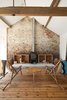 Modern home with Living Room, Chair, Coffee Tables, Standard Layout Fireplace, Storage, Ceiling Lighting, Medium Hardwood Floor, and Wood Burning Fireplace. Subverting the traditional, conservatively cozy British barn conversion, Carl Turner created a getaway in rural Norfolk for himself and his friends to visit, repose, and consider the beauty of agrarian minimalism. Turner reclaimed most of the timber used for the flooring as he renovated buildings in London. He thought his stockpile was big enough for the Ochre Barn, but the scale of the place defeated him. The solution, surprisingly, was eBay, turning up an old mill’s worth of boards. Photo of Winning Bids: 7 Unbelievable Online Finds