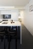 Casual meals are eaten at the kitchen’s glacier white Corian countertop, which features Aalto K65 stools. The island’s Blanco sinks offer a direct, uninterrupted sightline to the garden. Photo 5 of Cosgriff House modern home