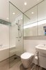 Situated behind the kitchen, the lower level bathroom is equally suited to cleaning up before a meal or taking a leisurely bath. Crisp white fixtures, including a Kaldewei Centro Duo bath, ensure that the bathroom feels as light and airy as the rest of the house. Photo 6 of Cosgriff House modern home