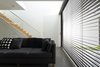 When the sun is at its brightest, the east-facing glass wall is shielded by retractable Horiso venetian blinds that have been powdercoated to match the extension’s charcoal cladding. Photo 7 of Cosgriff House modern home