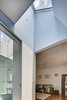 Save for a new fan and a coat of oil on its pine floors, the original living room remains unchanged. The master bathroom, however, has been completely refurbished with Scala accessories and a Duravit Happy D wall basin. Both rooms are brightened by skylights carved into the roof. Photo 9 of Cosgriff House modern home