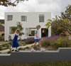During construction, workers enlivened the white, painted exterior of the 3,143-square-foot home by insetting some bricks with a rubber mallet, creating a muted pattern of shadows that dance across the façade. Photo of Riverview modern home