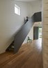 At the top of the steel staircase, a window-lined hallway wraps around the inner courtyard as it leads to the playroom. The upper level also includes the children’s bedrooms and bathroom. Photo 3 of Riverview modern home