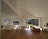 “The walls are painted brick to reinforce the connection to the exterior of the house,” Trimble says of the combined dining and living area. Clad in European oak flooring, the warm space features Series 7 chairs by Fritz Hansen, a Soverin Table by Andreu World, and a comfy, leather Marenco sofa by Arflex. Photo 4 of Riverview modern home