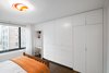 Modern home with Bedroom, Bed, and Storage. A custom unit with handleless, lacquered doors conceals a small workspace and ample clothes storage. Photo of Storage-Savvy Apartment Renovation in NYC