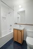 Modern home with Bath Room, Ceramic Tile Wall, and Drop In Tub. The navy floor tiles in another bathroom are from Mosaic House. Photo of Storage-Savvy Apartment Renovation in NYC