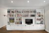 A large unit provides book and media storage in the living room. Photo of Storage-Savvy Apartment Renovation in NYC modern home