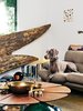 Modern home with Living Room, Sofa, Coffee Tables, and Rug Floor. In the living room, angel wings taken from a circa-1890s Parisian statue were discovered at Scott Landon Antiques in Vancouver. The vintage Petal coffee table, by Richard Schultz for Knoll, is topped with various brass and copper bowls found at secondhand stores, displayed alongside Form bowls by Tom Dixon. Photo of Fall Design Trend: Gold, Brass, and Copper Accents