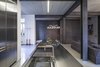 While the lower floor was the site of more extensive work, the entire interior was redressed in a raw, industrial style, heightening the contast between old and new. Photo 2 of Minimal Reboot modern home