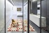 The new 860-square-foot basement contains a bathroom and additional living space. The designers chose to use pivoting glass doors so as to not cut into the space. Photo 3 of Minimal Reboot modern home