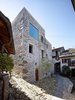 The end goal, a vacation home with a view of the nearby lake, led Jérôme de Meuron to cut through a wall and ceiling to open up the space. "We tried to preserves as much as possible," he says. The addition of the large upper story window adds daylight without altering the street-level character of the stone home. Photo 2 of Scaiano Stone House modern home