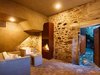 The former cellar, now an entrance with a built-in raw steel fireplace, welcomes guests. Plaster outlines the new staircase, where an old stonewall was cut out to provide a passageway to the upper level. Photo 3 of Scaiano Stone House modern home