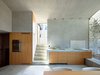 This alternative view of the kitchen and dining area, outfitted with KWC ONO and Sanitär Tröesch, exemplifies how reinforncing the walls and cutting through some of the stone brought significant light into the interior. Photo 6 of Scaiano Stone House modern home