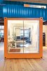 To say that Jeff Wardell and Claudia Sagan's apartment is truly unique would certainly be an understatement. Their 3,200-square-foot San Francisco abode, formerly a Chinese laundry and tooth-powder factory, holds onto its industrial roots with a tangerine-toned shipping container in the middle of the couple's living room. The container serves dual purposes as a guest bedroom, housing a Pat Carson–designed Murphy bed, and home office with the glass wall transforming from opaque to clear with a flick of a switch. Photo of How to Design with Orange modern home