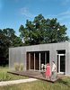 Modern home with Exterior, Cabin Building Type, Flat RoofLine, House Building Type, and Metal Siding Material. The front deck, invisible from the road, is an extension of the wood paneling in the main living space. Photo 12 of New Grass Roots