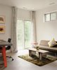 Modern home with Living Room, Sofa, Concrete Floor, Rug Floor, and Coffee Tables. A small room in the guest wing doubles as a lounge and studio, with a table designed by Richie and a Case Study daybed from Modernica. Photo 13 of New Grass Roots