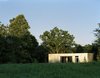 Modern home with Exterior, Cabin Building Type, House Building Type, and Flat RoofLine. From the road, it could be easy to mistake this modern hideaway for a typical farm shed. At sundown, light gleams off the metal exterior, glowing amid lengthening shadows. Photo 19 of New Grass Roots