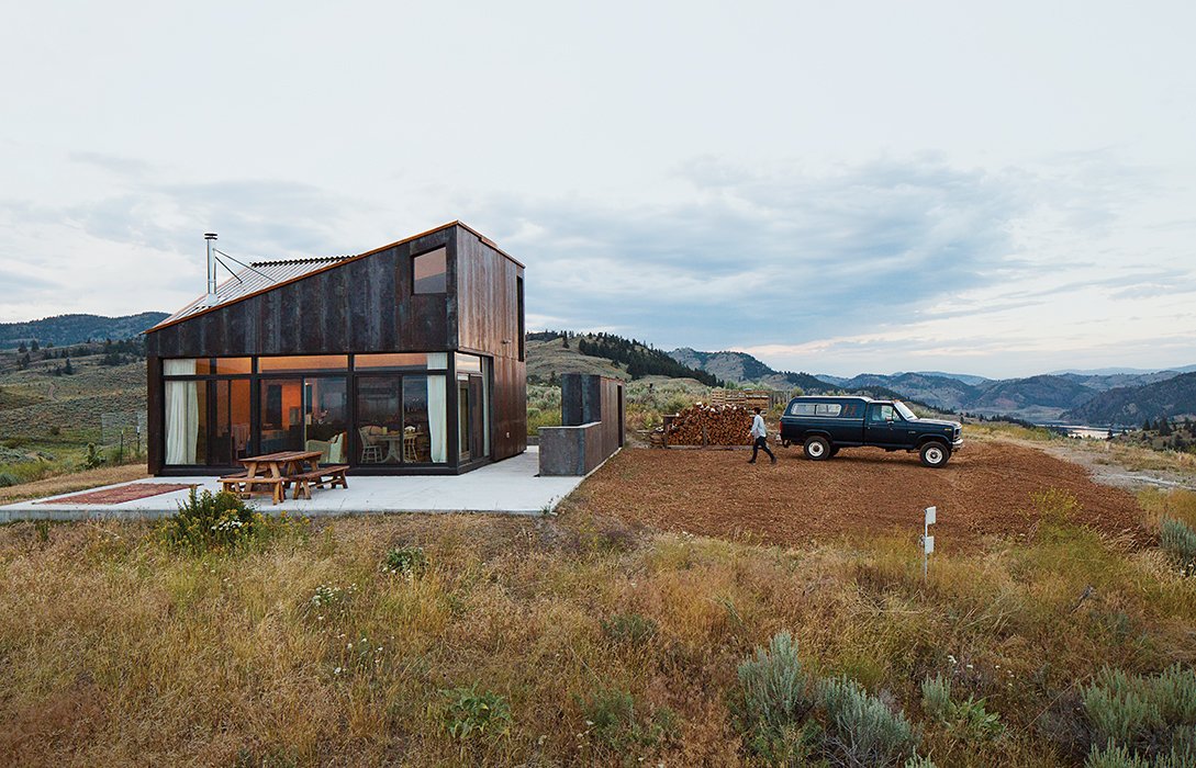 Architect Jesse Garlick’s rural Washington vacation home references its rugged surroundings. The steel cladding has developed a patina similar to the ochre-red color of bedrock found in the area.