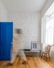 The blue entry door packs a punch in the neutral living area, which is sparsely furnished with inexpensive pieces — some from local Portuguese companies, others self-made or purchased in flea markets. Photo of Blue Mood: 9 Creative Ways to Use Color modern home