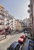 Rocha says situating the flat’s social areas toward the street “enabled a certain traditional way of living characteristic of these historic neighborhoods, where you know and talk to the people that live around you — a rare circumstance in contemporary cities.” Photo of Minimal Apartment in Lisbon Divvied Up by Sliding Doors modern home