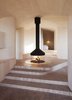Modern home with Living Room, Hanging Fireplace, and Marble Floor. Atelier Oslo overcame nature’s challenges when they designed Cabin Norderhov, a seasonal, eco-friendly retreat on a steep hillside overlooking Lake Steinsfjorden. The home’s layout revolves around a central glass and metal "campfire" that burns beneath a suspended mantel. Since it’s located at the access level, the fireplace's flickering warmth can be enjoyed throughout the house. The surrounding floor is covered with hexagon tiles cut from marble, which transition into tiles made of birch log in the rest of the house. Photo 2 of Cabin Norderhov