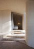 The hideaway grows darker as residents move through the space toward the bedroom. The only light in the sleeping space enters indirectly from the nearby glass façade, as well as from a small ventilation window in the northern corner. Photo 6 of Cabin Norderhov modern home