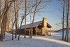 While a lengthy building lifespan minimizes environmental impact—for example, the charred cedar will last 80 years—an array of solar panels 50 yards from the house also allows it to operate independently from the electrical grid. A cistern collects fresh water from a nearby natural spring. Photo 2 of Off-Grid Retreat modern home