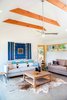 The bright ochres of the Douglas Fir beams and window framing accent the gray and white hues of the furniture, floors, and walls. Photo 6 of Off-Grid Retreat modern home