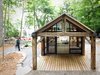 Modern home with Exterior, Cabin Building Type, House Building Type, Gable RoofLine, and Wood Siding Material. These rustic roof beams were also recovered from the barn and support a covered patio at the rear of the Bunkie. Photo of High-Tech Prefab Outbuilding is a Surprisingly Peaceful Retreat