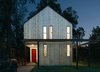 Modern home with Exterior and House Building Type. The streamlined shape of the home kept slab, framing, and roofing costs down, Pavonetti explains. A barn red shade on the front door adds a touch of farmhouse whimsy to the modern structure. Photo of Bright, Personality-Filled Home Built on a Budget in Austin