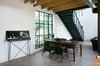 Modern home with Dining Room, Chair, Concrete Floor, and Table. "By providing a clean modern base of crisp white walls, the more rustic and industrial materials stand out and give warmth and nostalgia not found in a starkly," Pavonetti says. Photo of Bright, Personality-Filled Home Built on a Budget in Austin modern home