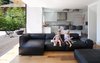 Modern home with Living Room, Light Hardwood Floor, and Sectional. The addition of a living room beside the kitchen lets mom and dad spend more time with their kids – and watch over their activities. The children are sitting on a NeoWall couch by Living Divani, the light fixtures above the island are Smithfield by Flos, and the floor is oak. Photo 17 of Trotman Residence