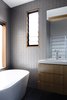Modern home with Bath Room, Wall Mount Sink, and Freestanding Tub. In the serene upstairs bathroom, Kennon paired Chinese Bluestone floors from Defazio with white ceramic wall tiles from local supplier Classic Ceramics. The tub is by Bette with a Roger Seller faucet, while the bathroom sink is by Argent with a Grohe faucet. Photo 7 of Lush Hill