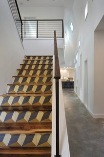 An intricately detailed staircase leads to the central wing’s second level. Its walnut treads and top rail harmonize with the welded steel rod railings. The geometric pattern on the staircase’s risers comes from encaustic tiles that were handmade in Tuscaloosa, Alabama.