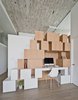 Modern home with Office, Study Room Type, Chair, Desk, Bookcase, Storage, and Shelves. Gaps and openings between the handle-less, white oak shelves are functional and decorative, holding plants, books, and office supplies. Small touches, such as the matching color of the chair and the lower shelves, help accent the clean white surfaces. Photo of Brooklyn Loft Renovation Masters Storage with a Custom Cabinet Wall
