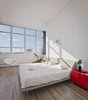 Modern home with Bedroom, Bed, Storage, Chair, and Medium Hardwood Floor. Last but not least, the western-facing master bedroom captures stunning sunsets from its wall-to-wall windows. Photo of Brooklyn Loft Renovation Masters Storage with a Custom Cabinet Wall