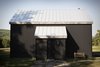 Modern home with Exterior, Cabin Building Type, Metal Roof Material, Gable RoofLine, and Metal Siding Material. In Scandinavian regions, traditional cabins are painted black using a mixture of tar and linseed oil. Peck reproduced the look using corrugated metal—a lower-maintenance, more sustainable material. “We love that it is black, because it really reminds us of home,” Bronee says. The house has no windows on its front side, belying its light-flooded interior. Photo of A Slice of Scandinavian Design in the Catskills
