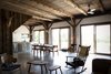 Modern home with Living Room, Chair, Concrete Floor, and Coffee Tables. The house captures meadow views, thanks to three large sliding doors by Loewen that lead out to a big deck. “We wanted to hide the view from visitors until you get inside, so it would feel like a surprise when walking in,” Bronee says. “This also gives us the sense of being tucked in and cozy in the winter with a view of the meadow, and in the summer it feels like indoors and outdoors are connected. We live just as much on the deck as we do inside.” Photo of A Slice of Scandinavian Design in the Catskills
